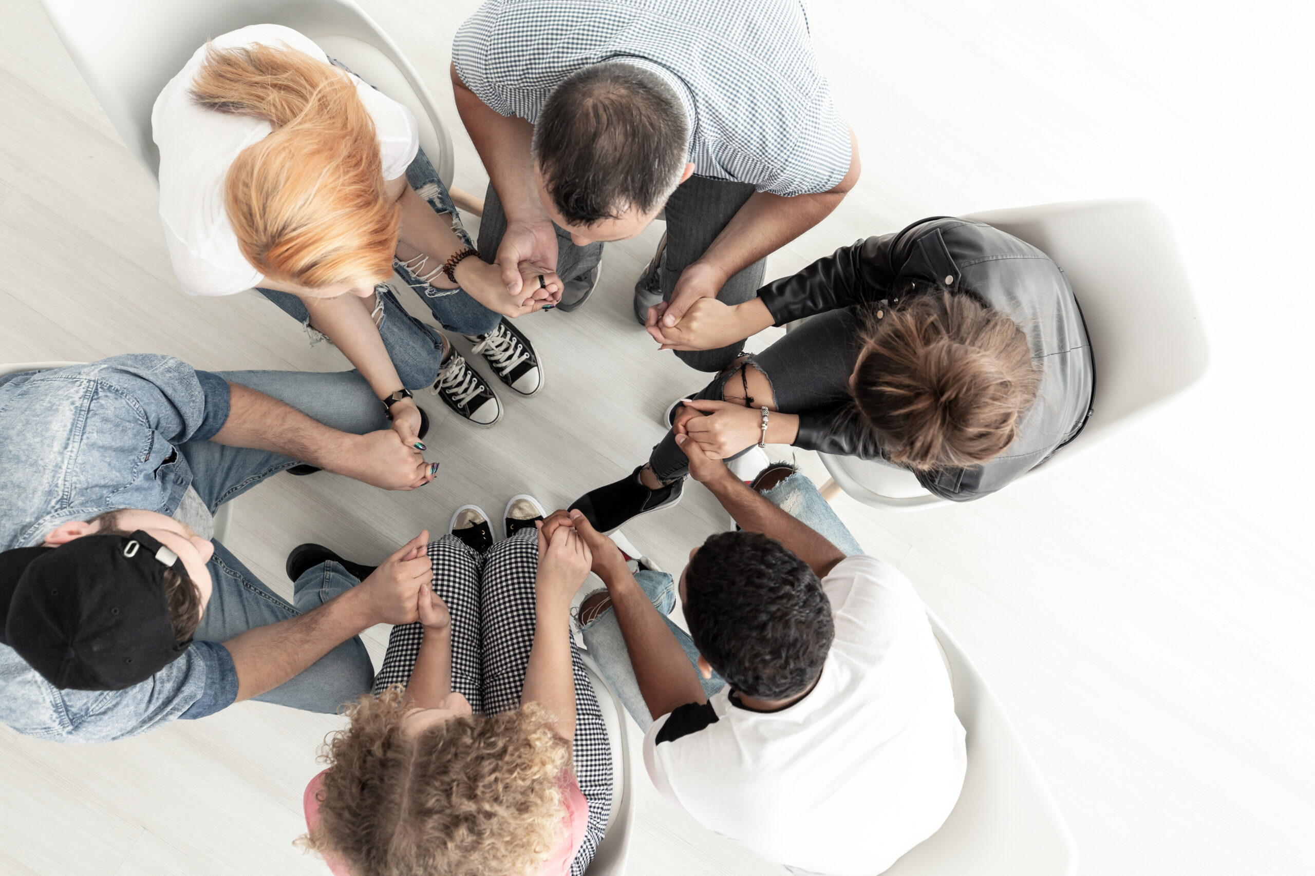 Top view on psychotherapist supporting teenagers with alcohol addiction during therapy